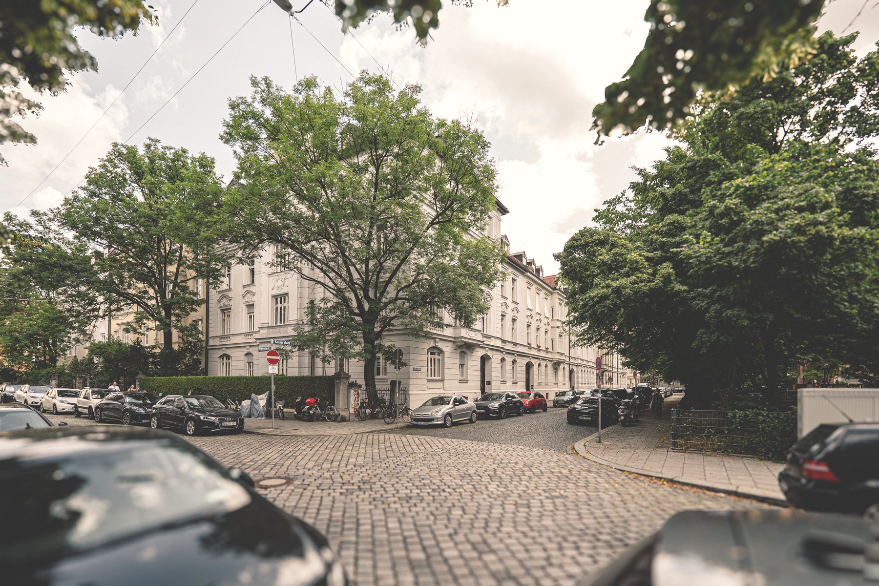 Baumgesäumte Wohnstraße mit Kopfsteinpflaster